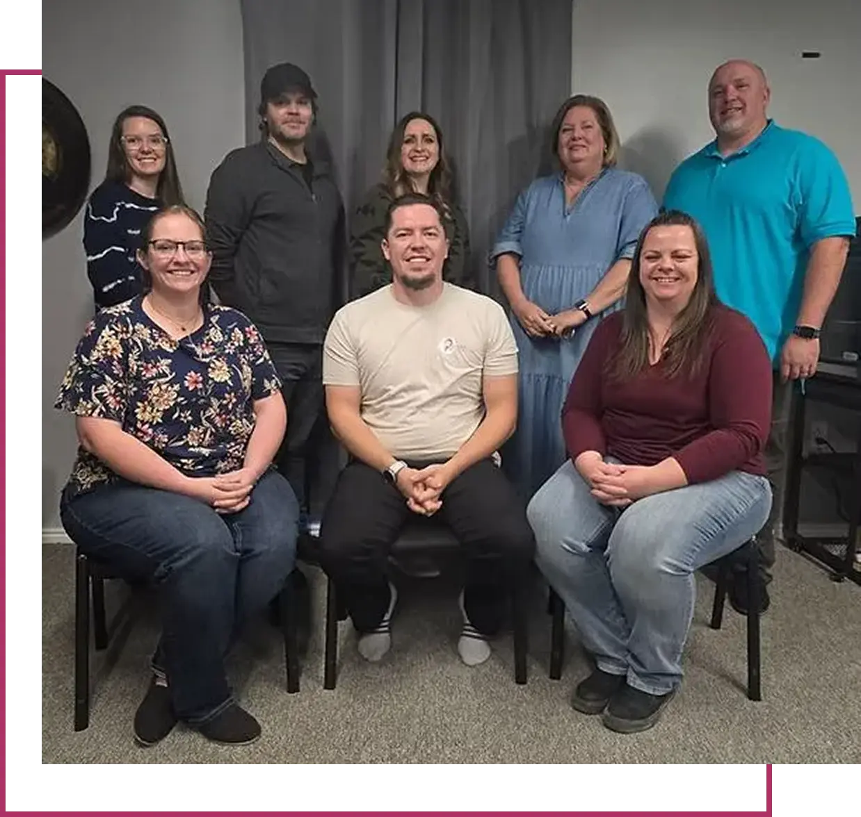 Group of seven people posing together indoors.